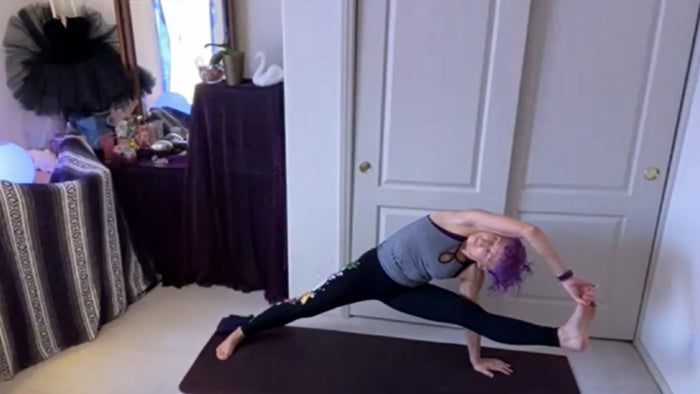 A woman doing yoga at home with legs in splitting position