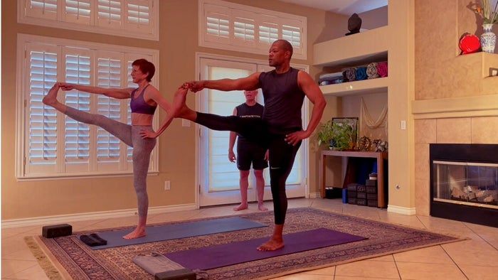 Two yoga students with one-leg standing and the other leg stretch in front